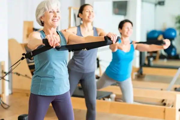 Toning Arms After 60: Empowering Womens Fitness Through Effective Weight Training 2 older woman doing weight training Wales and resistance in the gym to tone upper arms