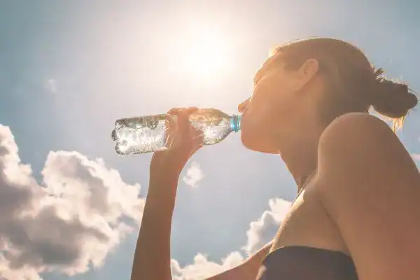 Hydration: The Secret Ingredient for a Toned Stomach and Enhanced Fitness 3 Image of woman drinking water to hydrate Wales after run.